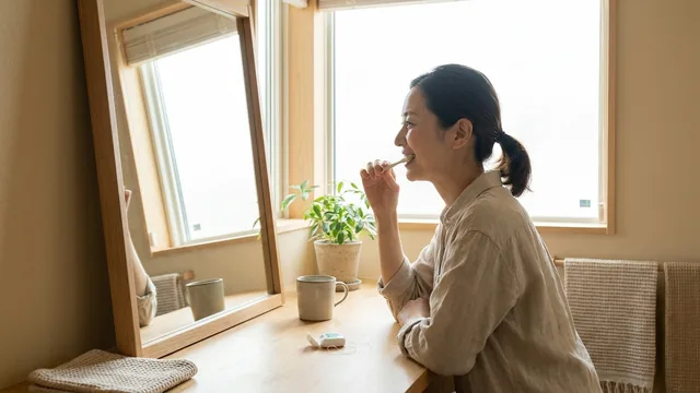 洗面台で歯みがきをする女性